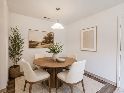 A dining room with a round table and chairs.
