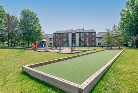 a park with a playground and a sandbox in the grass