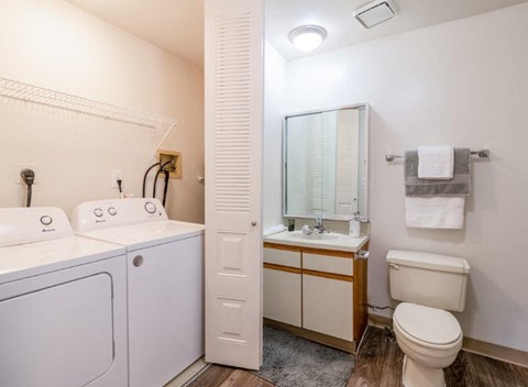 a bathroom with a washer and dryer and a sink and toilet