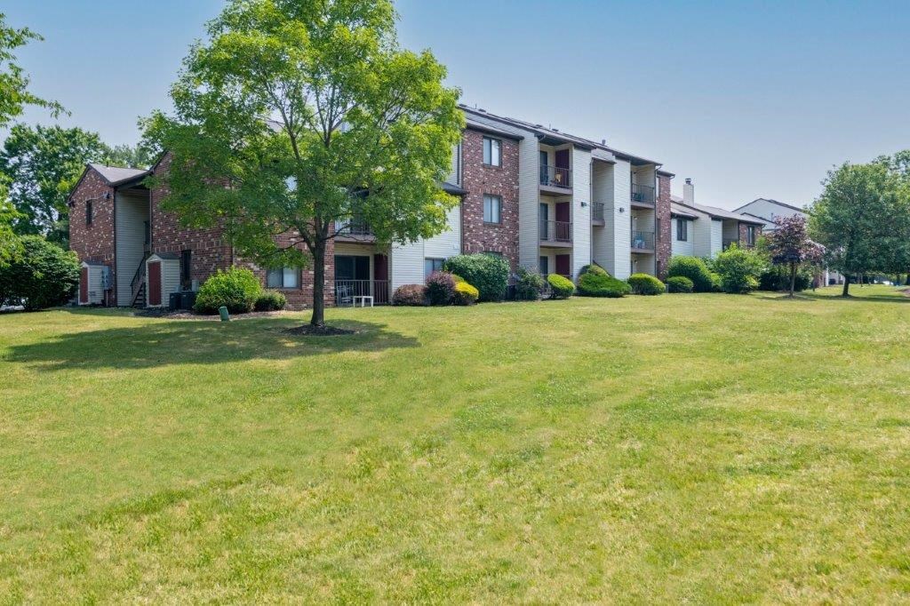 a large green lawn in front of an apartment building