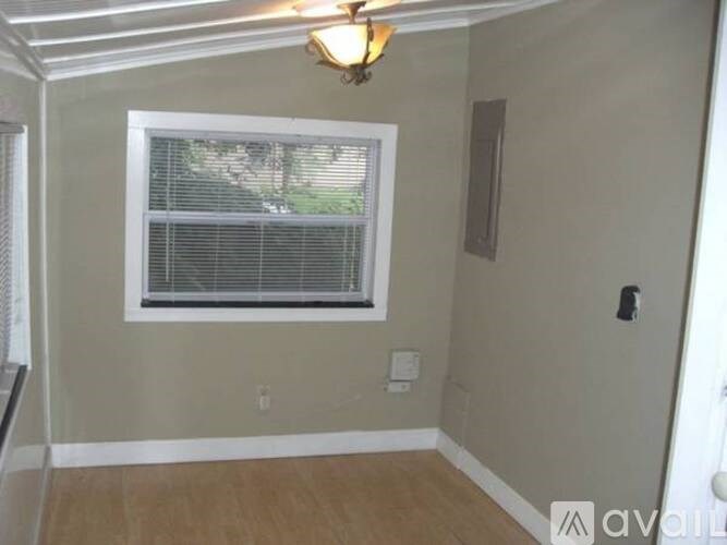 A room with a window and a light fixture on the ceiling.