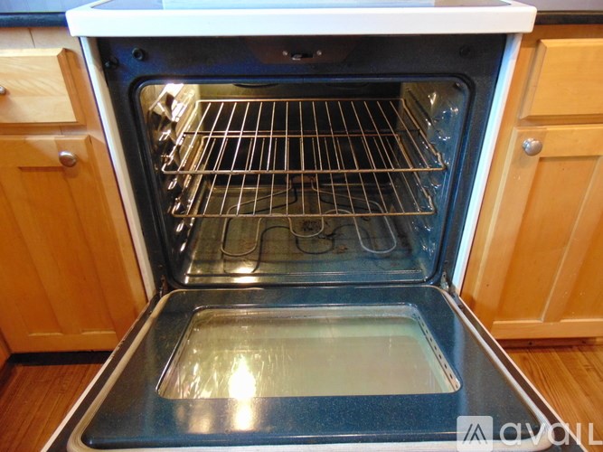 A small white shed with a brown roof and a white door.