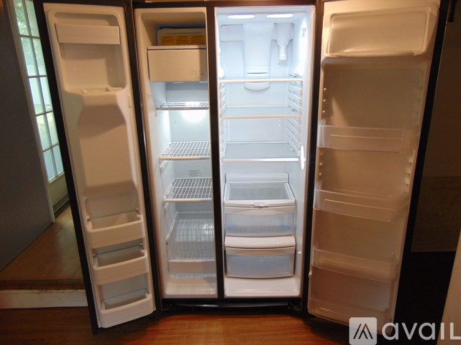 A white refrigerator with its door open showing the shelves and drawers.
