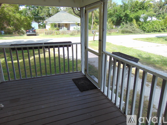 A spacious room with a ceiling fan and wooden flooring.