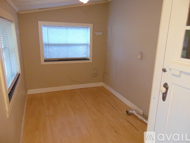A room with a window and wooden flooring.