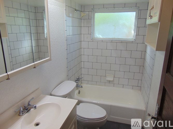 A bathroom with a white toilet, sink, and bathtub.