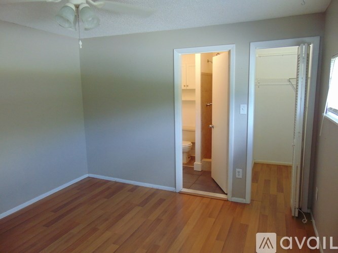 A room with a wooden floor and a ceiling fan.