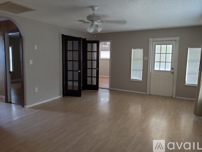 A room with a ceiling fan and wooden flooring.