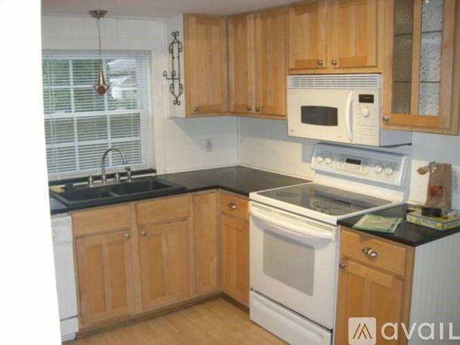 A kitchen with wooden cabinets and black countertops.