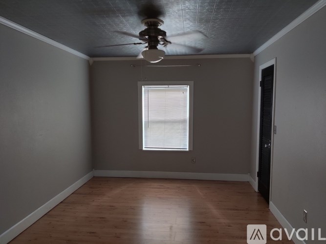 A room with a ceiling fan and a window.