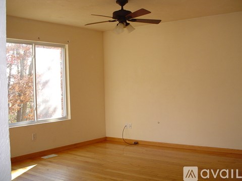 Empty room with a ceiling fan and a window.