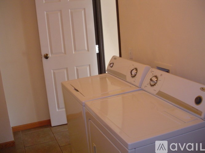 A white door is in a room with a washer and dryer.