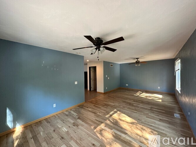 A room with wooden flooring and a ceiling fan.
