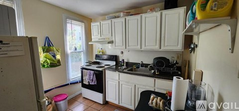 A kitchen with white cabinets and a black stove top.