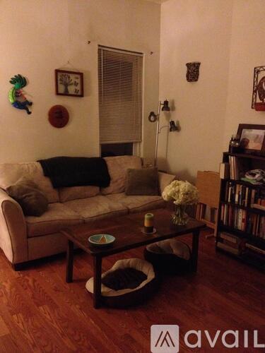 A living room with a couch, coffee table, and bookshelf.
