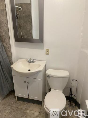 A white toilet sits next to a sink in a bathroom.
