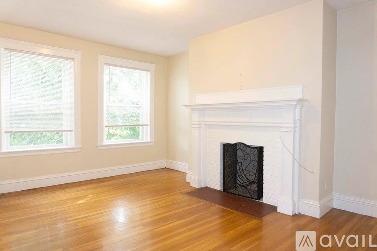 A room with a fireplace and two windows.