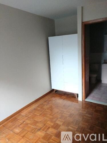 A room with a white cabinet and wooden floor.