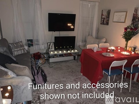 A living room with a red table set for a meal.
