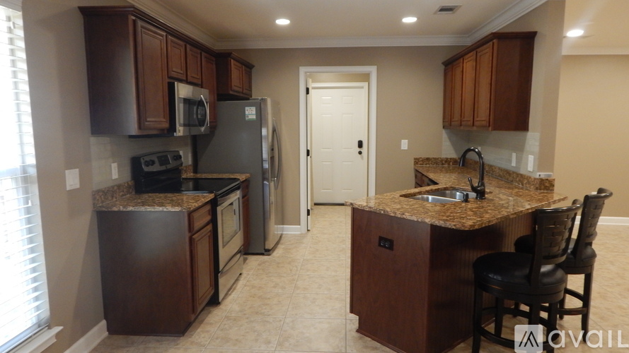 A kitchen with brown cabinets and granite countertops.