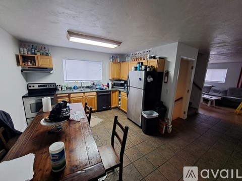 A kitchen with wooden cabinets and a black fridge.