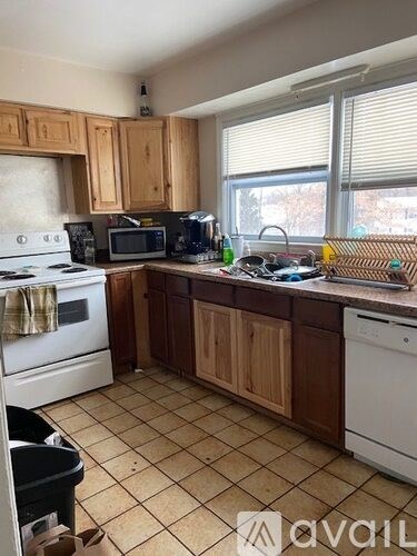 A kitchen with wooden cabinets and a white dishwasher.