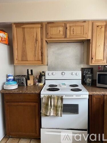 A white stove top oven with a towel hanging on it.