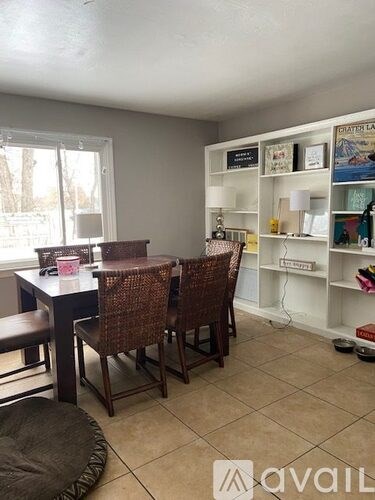 A dining room with a table and chairs.