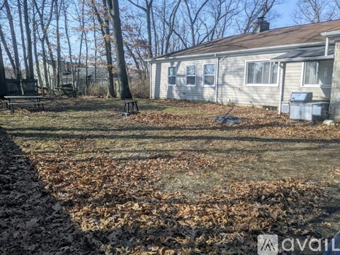 A house with a lawn and trees in the background.