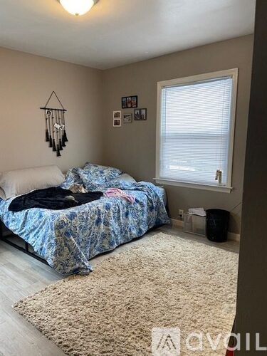 A bedroom with a bed covered in a blue and white patterned comforter.