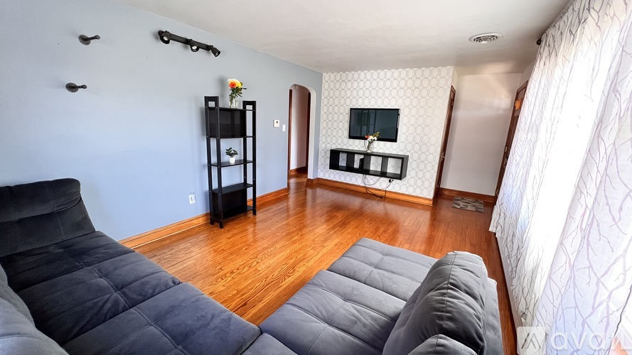 A living room with a grey sofa and a black chair.