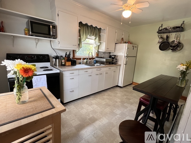 A kitchen with white cabinets and a black stove top oven.