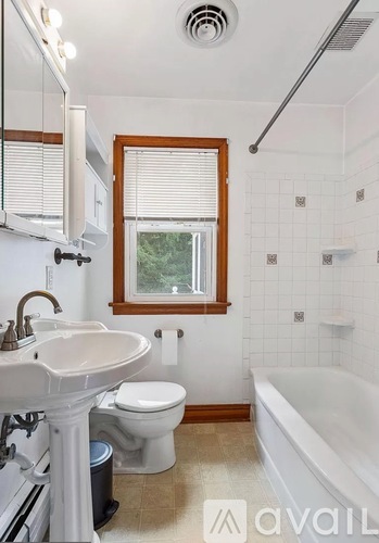 A white sink and toilet in a bathroom with a window.