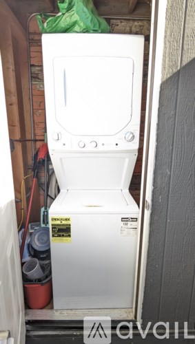 A white toilet is in a small space with a green bag in the background.