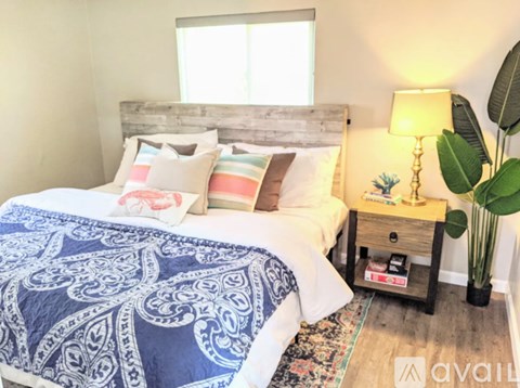 A bedroom with a bed covered in a blue and white patterned comforter.