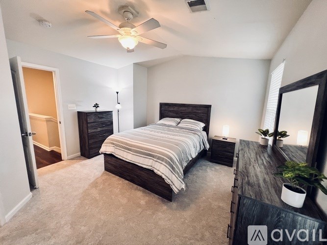A bedroom with a large bed and a ceiling fan.