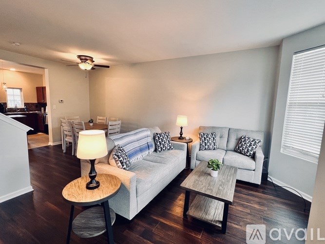 A living room with a grey couch, a wooden table, and a lamp.
