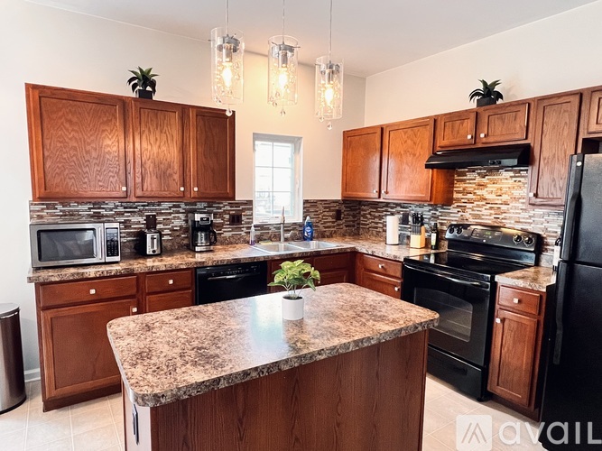 A kitchen with wooden cabinets and granite countertops.