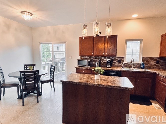 A kitchen with a table and chairs in front of a window.