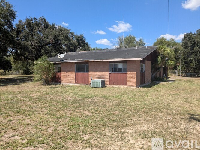 A dog is standing in the grass near a fence.