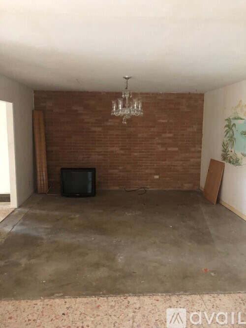 A room with a brick wall and a television set.