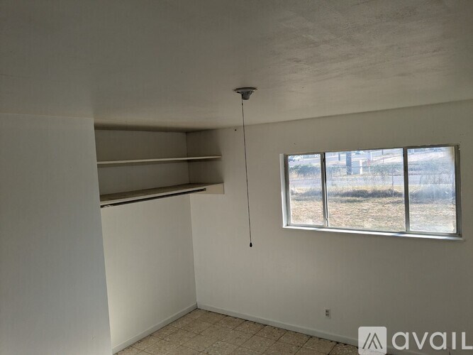 A room with a chandelier and two windows.