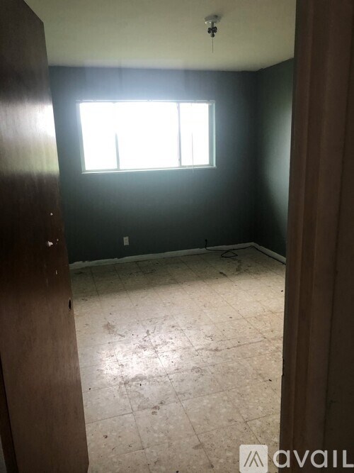 A room with a window and a tiled floor.