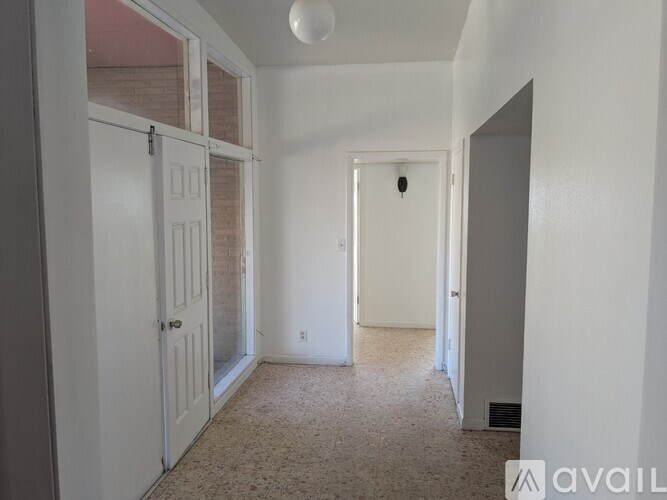 A room with a carpeted floor and a door on the left side.