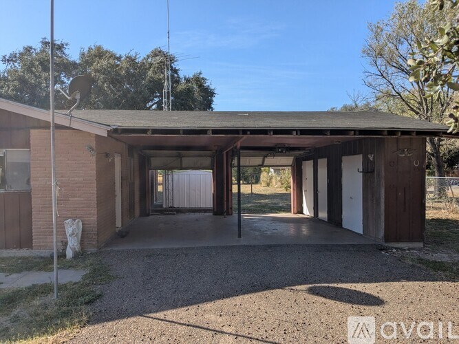 A house with a gravel driveway and a satellite dish on the roof.
