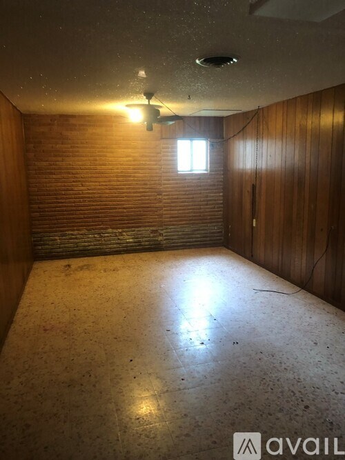 A room with wooden walls and a window.