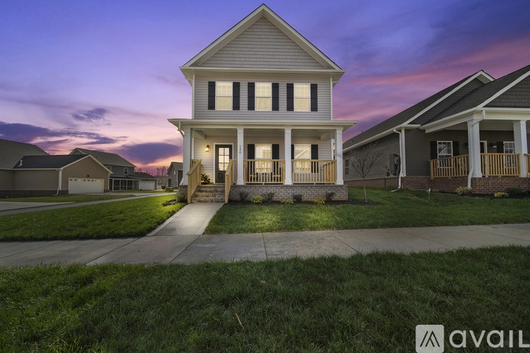 A house with a front porch and a driveway in front of it.