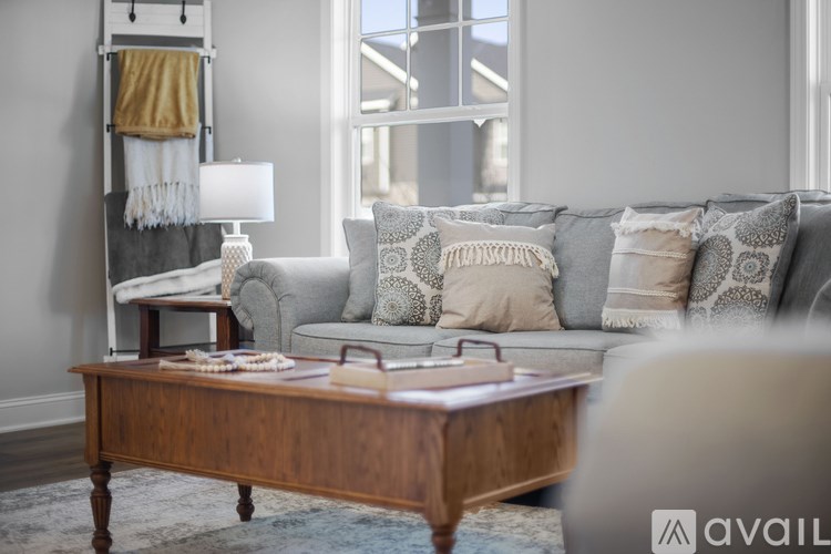 A living room with a grey couch and a wooden coffee table.