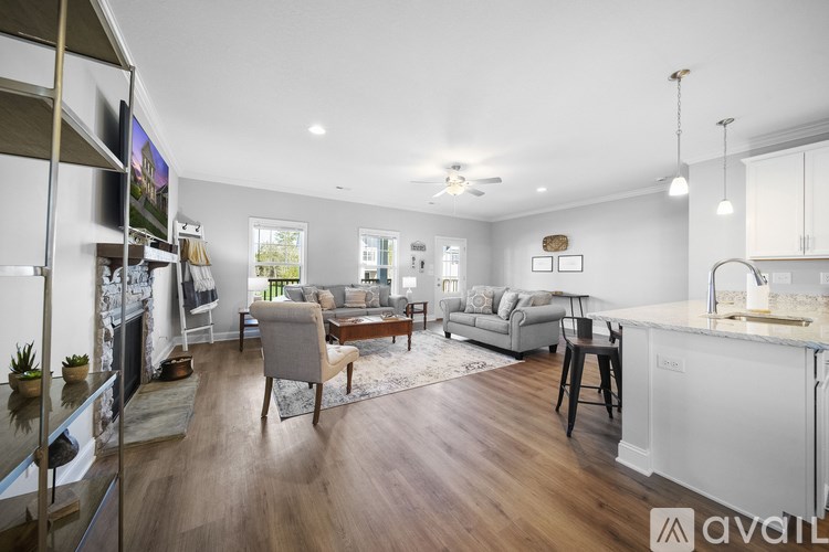 A modern living room with a kitchen area in the background.