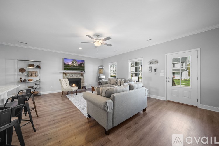 A spacious living room with a grey sofa and a fireplace.